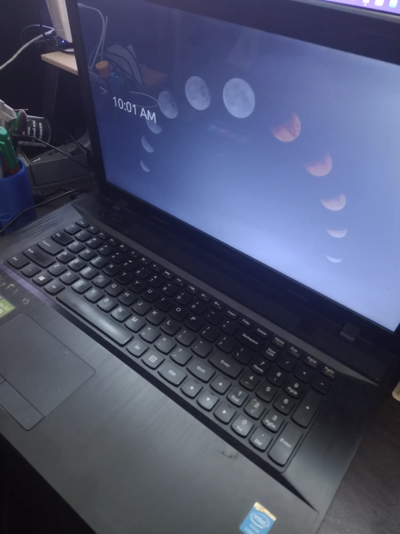 The salvaged Lenovo G710 open and running — moon-phase wallpaper, clock reading 10:01 AM — in active hosting duty.